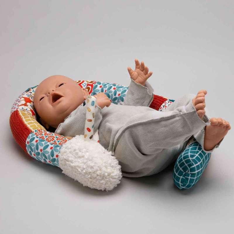 a baby doll lying in a bed